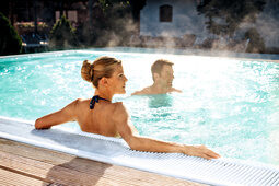 Das Thermalwasserbeecken eines Wellnesshotels bietet einem Paar Erholung und Freizeitvergnügen in Bad Füssing.