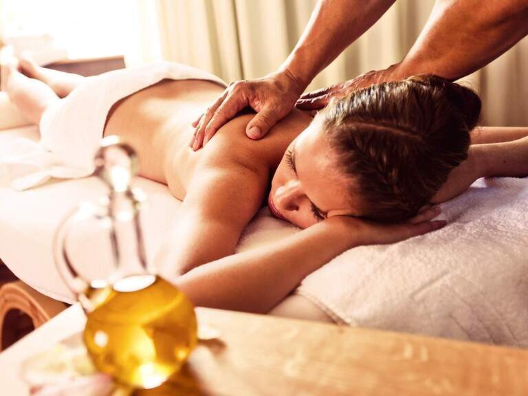 Eine Frau genießt eine entspannende Massage in einem Hotel von Bad Füssing.